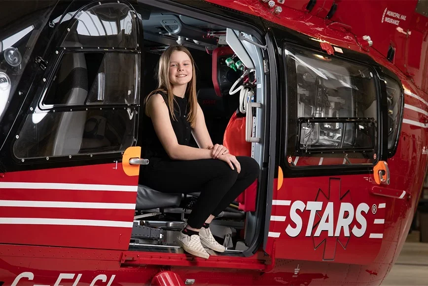 Photo of Jorja Strauss sitting on the edge of the STARS helicopter Photo of Jorja Strauss sitting on the edge of the STARS helicopter